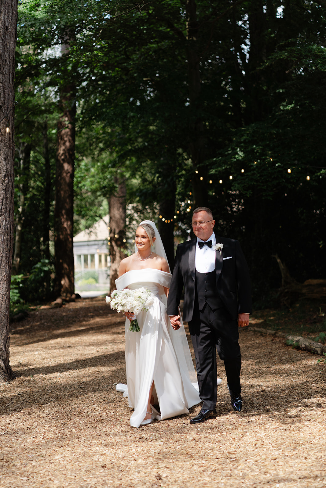 bride and her dad walk down the aisle in the woods at hobbit hill