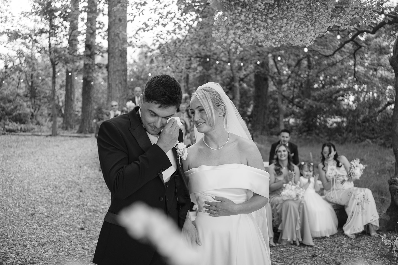 groom wipes away tears during wedding ceremony