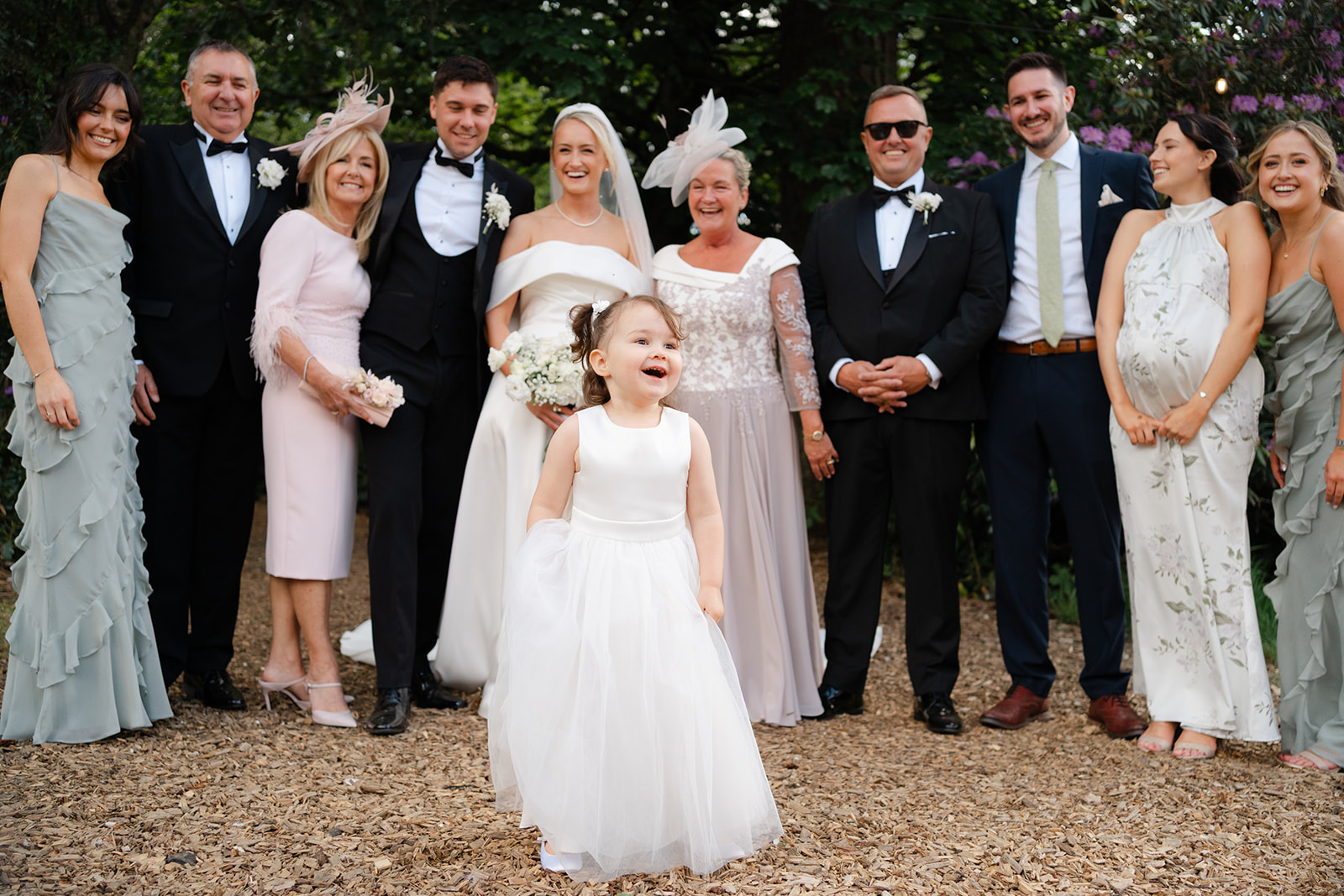 cheeky flower girl disrupts formal group photograph