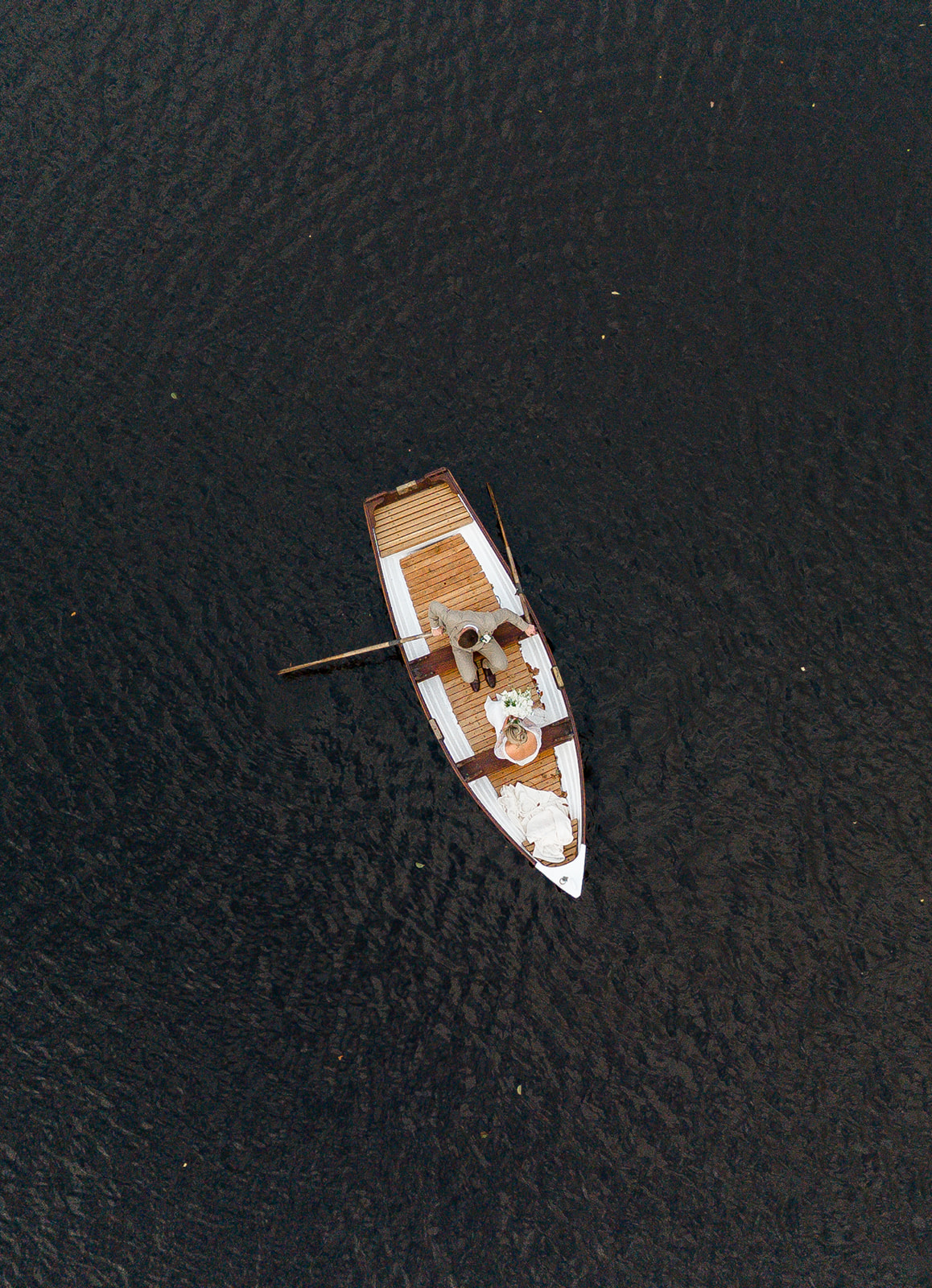 aerial photo of bride and groom in rowing boat