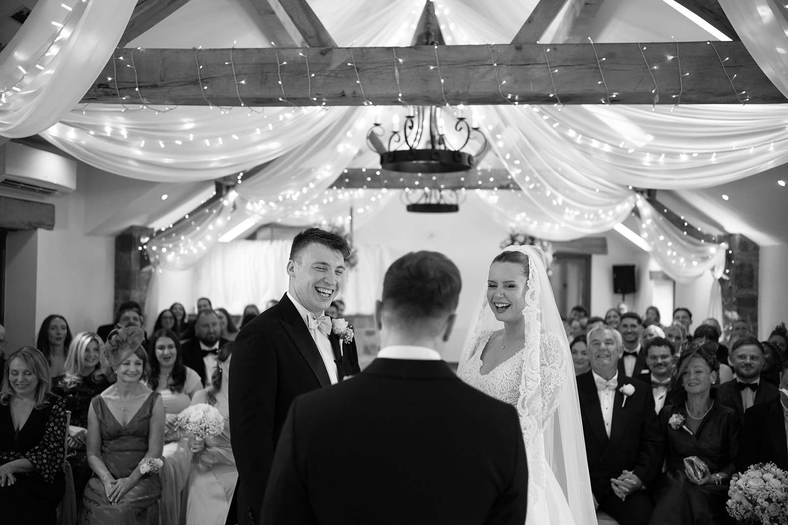 bride and groom smile at celebrant during beeston manor wedding ceremony